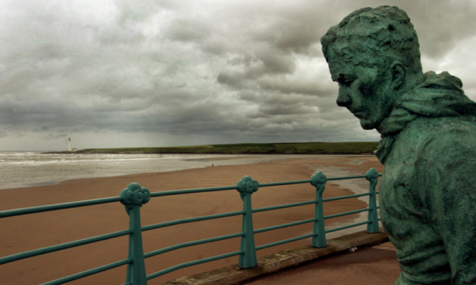 The William Lamb figure 'Minesweeper' looks out over a rain and wind swept Montrose Beach.
