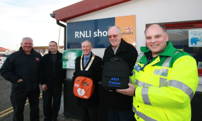 Arbroath Rotary president Iain Grimmond, centre, hands over the defibrillator. Also, from left: Alex Smith of Arbroath RNLI, Roddy Adam of Contact Electrical Services Ltd, Rotary defibrillator project manager Mike Sowden and James Williamson, Arbroath First Responders coordinator.
