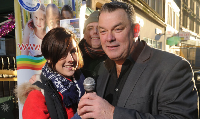 Jimmy Smart lending a hand and a voice at the sale of the Eagle Inn charity CD with Katelyn and Andy Goudie.