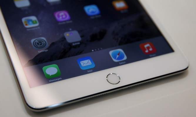 FILE - OCTOBER 20:  According to reports October 20, 2014, Apple announced a record of $8.5 billion in fourth quarter profit on $42.12 billion in revenue. CUPERTINO, CA - OCTOBER 16:  A touch I.D. pad is seen on the new iPad Mini 3 during an Apple special event on October 16, 2014 in Cupertino, California.  Apple unveiled the new iPad Air 2 and iPad Mini 3 tablets and the iMac with 5K retina display.  (Photo by Justin Sullivan/Getty Images)