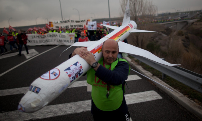 A member of the Spanish Airline Iberia carries a model plane during a protest against job cuts at Barajas Airport in Madrid