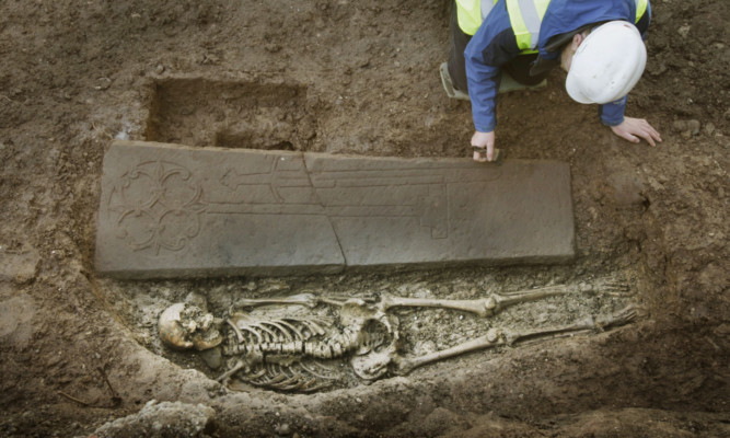 Ross Murray at the grave of a medieval knight that has been discovered under an old city car park in Edinburgh.