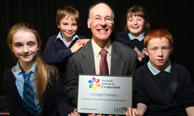 Chair of Co-op Group Robin Stewart presents the award to pupils.