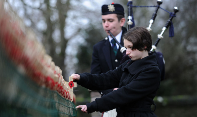 Ruaridh and Rhiannon Proctor honour Private George Reid at Balhousie Castle's memorial wall.