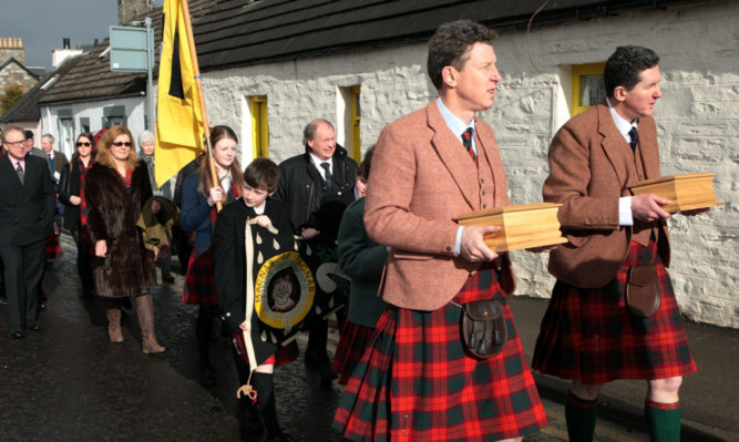 Jamie and Jeffrey Macnab at the head of the procession with the caskets of their father and mother.