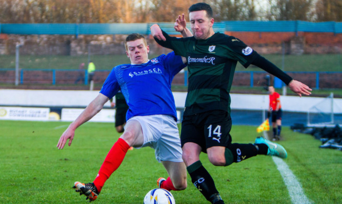 Cowdens Jon Robertson tries to prevent Ryan Conroy from getting a cross in.