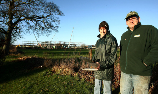 Clear volunteers Pauline Normand and Colin Pentland at Starkies Wood, with the school in the background.