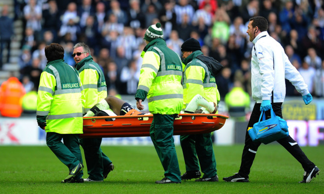 Newcastle United's Massadio Haidara is carried from the field injured following a tackle by Wigan's Callum McManaman.