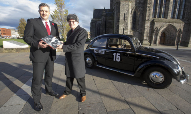 Mark Macmillan, leader of Renfrewshire Council, and Douglas Anderson with his book at Paisley Abbey