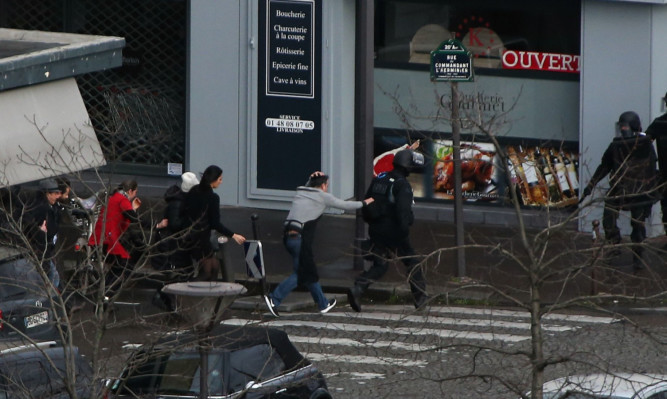 People are led away from the hostage scene at the supermarket in Paris.