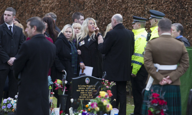 Private Mark Connollys mother Linda McComiskie, centre, visibly upset at Newmonthill Cemetery, Forfar.