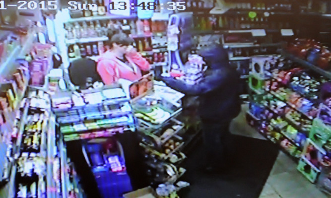 Security camera footage of Kirsten Beveridge being robbed by the thief who is threatening her with a screwdriver.