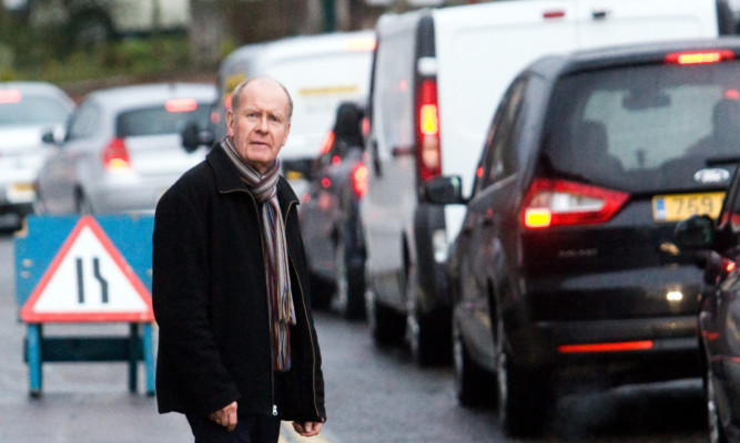 Councillor Willie Wilson sees the problems caused by queueing traffic at roadworks.