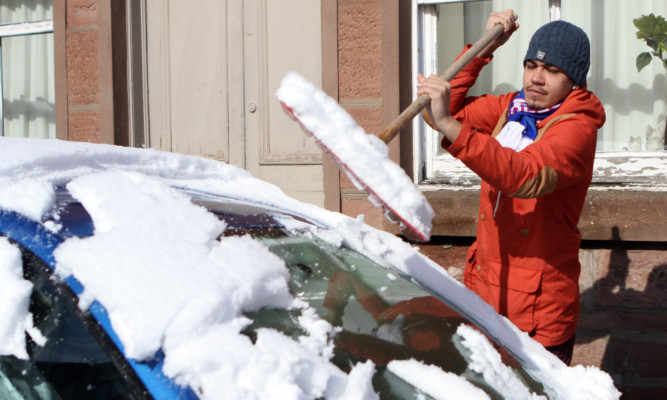 Jamie Urquhart clearing snow from a car in Kirriemuir.