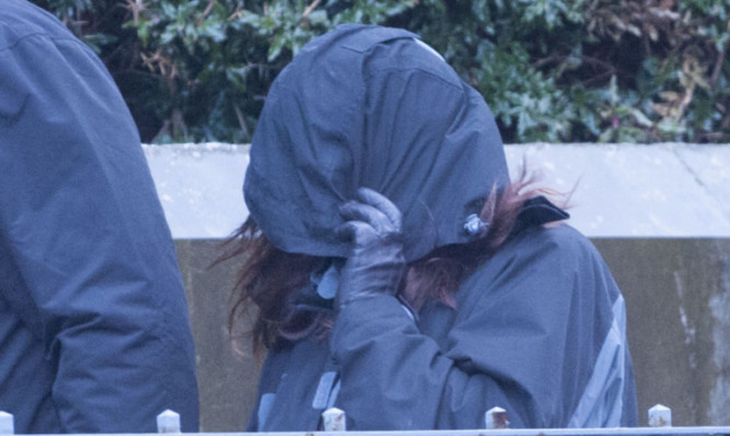 Warden hides her face as she arrives at Dundee Sheriff Court.