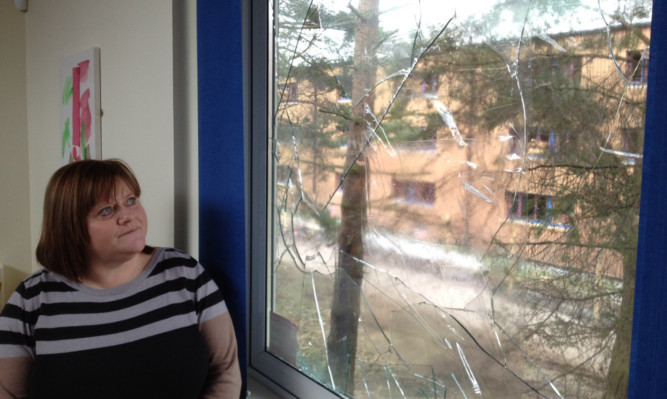 Hillview manager Frances Benmalek beside the latest smashed window.