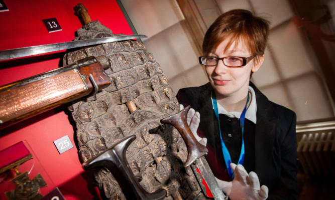 Collections assistant Nicola Moss alongside the crocodile skin shield.