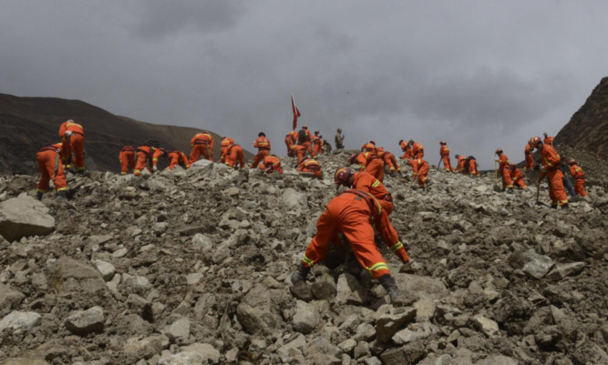 Rescue workers conduct search and rescue work at the site where a large-scale landslide hit a mining area in Maizhokunggar County of Lhasa.