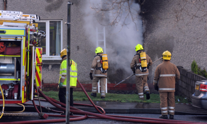 Firefighters tackle the flat blaze on Wilson Street, Blairhall.