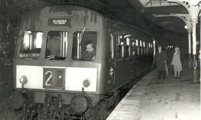 black and white photo of Dundee-bound train leaving St Andrews Station, waved off by a couple on the platform, in 1969.