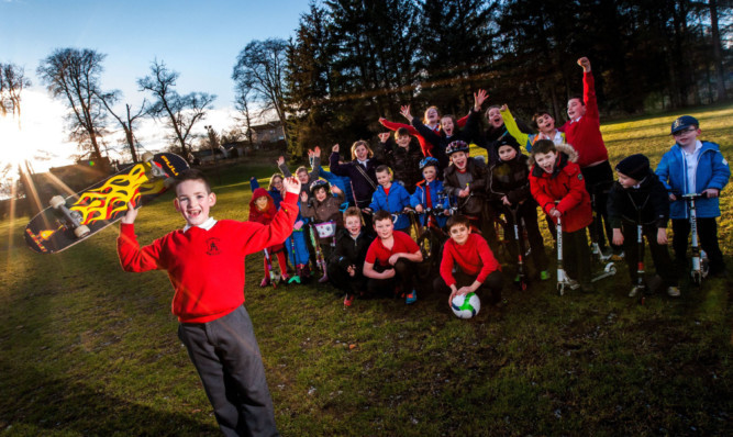 Children from the school, including P6 pupil Craig Ewan, front, gather on the possible site of the skatepark.