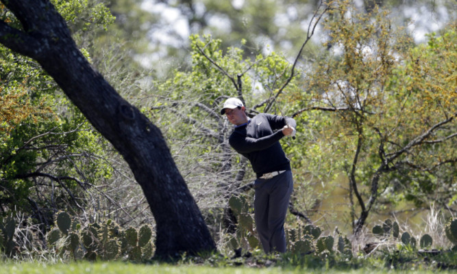 Rory McIlroy, hits from the rough on the eighth hole during the first round of the Texas Open.