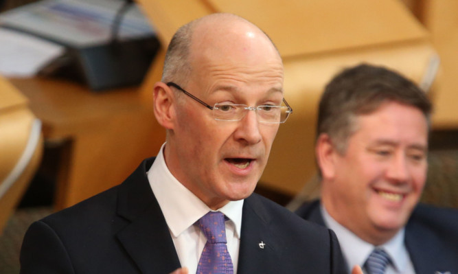 Deputy First Minister and Finance Secretary John Swinney in the debating chamber to announce his draft budget statement.