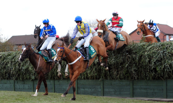 Little Josh ridden by Sam Twiston-Davies (left) clears Becher's Brook during the John Smith's Topham Steeple Chase during Ladies Day.