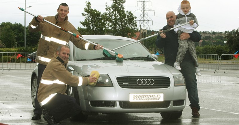 DOUGIE NICOLSON, COURIER, 04/07/10, NEWS.
DATE - Sunday 4th July 2010.
LOCATION - Dundee Ice Arena.
EVENT -  Charity Car Wash.
INFO - Charlie Kean, right, with Mikey Purvey, age six and a half, with Firefighters Nick Yeats, back, and Gordon Samson from Blue Watch at Macalpine Fire Station.
STORY BY - Reporters.