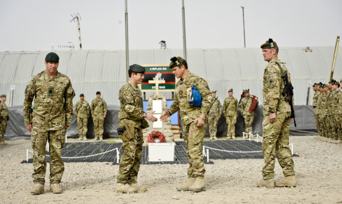 Commanding Officers Lieutenant Colonel Tom Bewick, 4 Rifles, (second left) and Lieutenant Colonel Ben Wrench, 1 Scots (second right) shake hands at the flag handover ceremony.