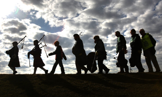 Pipers Su-Rui Laing and Glen Kelly leading some of the volunteers off.