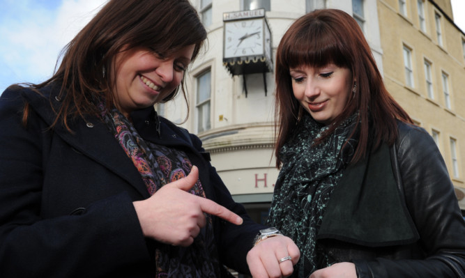 Laura Millar and Jenna Graham check the time.