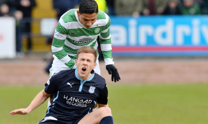 Greg Stewart in pain after a clash with Celtic's Emilio Izaguirre.