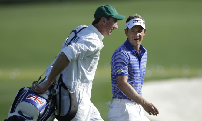 Luke Donald (right) walks to the driving range with his caddie John McLaren during a practice round for the Masters golf tournament.