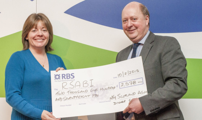 RSABI chief executive Nina Clancy with a cheque for £2,578 raised at the NFUS annual dinner and presented by outgoing union president Nigel Miller.
