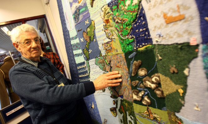 Trustee Jim Mitchell beside the tapestry.