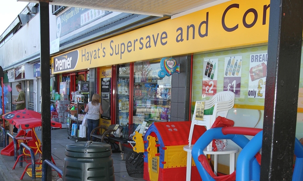 G Jennings pic,   Afzal  Hayat,  of Hayats superstore in Happyhillock shopping centre is offering a reward of ice cream cones to anyone who can help catch the person who stole their ice cream sign..... pic shows  the spot where the sign was taken from.