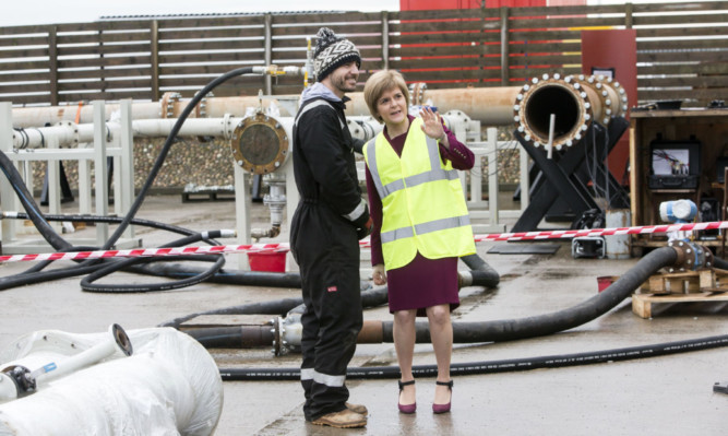 First Minister Nicola Sturgeon talks to technical specialist Euan Gibbons during a visit to pipeline support service provider Pipelines 2 Data in Aberdeen.