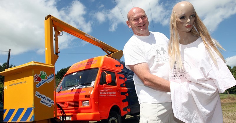 Steve MacDougall, Courier, Birch Cottage, Brigton of Ruthven, near Meigle. Meigle, Picture of Trevor Robertson. He's travelling from Perth to Mongolia in a cherry-picker, as part of the Mongol Rally.  He has specially printed t-shirts with his team name "The Bald Avengers" written on it, as well as a bald mannequin called 'Cherrie', which he is taking with him "for company".