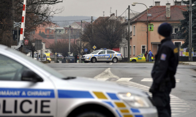 A police officer patrols near a restaurant where a gunman opened fire injuring at least one person in Uhersky Brod, in the east of the Czech Republic.