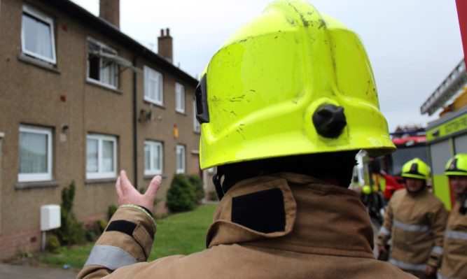 Kris Miller, Courier, 05/06/13. Picture today shows firefighters at a flat in Auchrannie Terrace, Dundee where a woman was checked by paramedics after a fire.