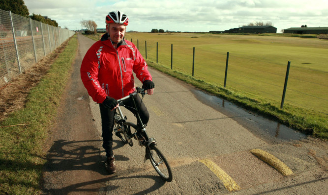 Cyclist Billy Smith on the path where he fell, between Carnoustie Golf Course and the railway fence.