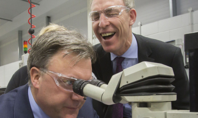Shadow Chancellor Ed Balls soldering a part of an aircraft with Scottish Labour leader Jim Murphy (right) during a visit to Walker Precision Engineering in Glasgow.