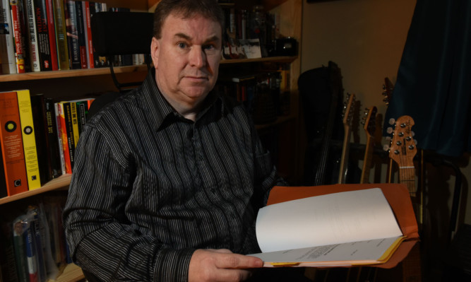 Patrick Kelly with some of the medical files relating to what he believes is his 'botched' back operation.