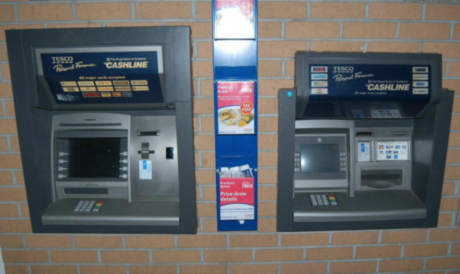 A photo previously released by police showing an ATM with a skimming device on the left, and a genuine machine on the right.