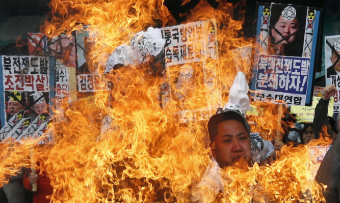 Protesters in South Koreas capital, Seoul, burn effigies of North Korean leader Kim Jong-Un and former leaders Kim Jong II and Kim II Sung.
