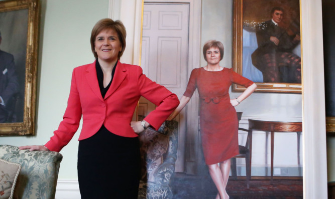 First Minister Nicola Sturgeon stands next to her life size portrait.