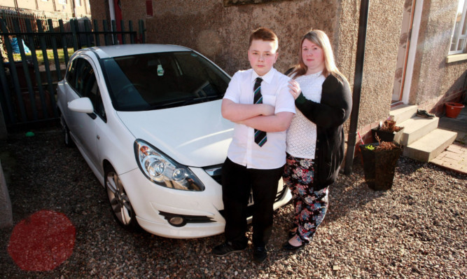 Gillian Garty and her son Logan beside their vandalised car on Balmuir Road.