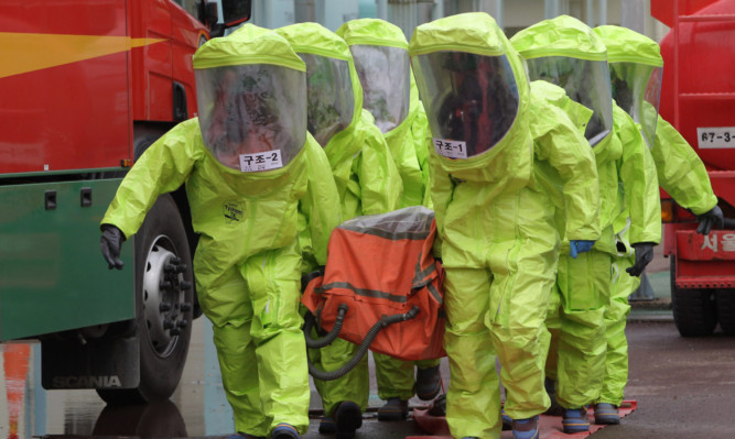 Emergency service personnel wearing chemical protective clothing participate in an anti-chemical warfare exercise in Seoul, amid rising tensions with North Korea.