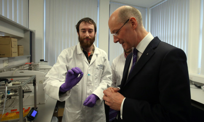 Deputy First Minister John Swinney views a 3D structure made by the 3D Bio Printer, held by Dr Alan Faulkner-Jones, during a visit to the Heriot-Watt Life Sciences Laboratory.